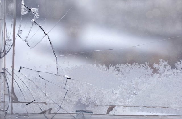 Broken window in the winter time with frost on the glass