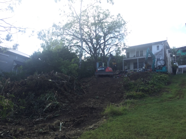 BEFORE backyard. Bulldozers are brought in to removes the piles of rubbish and begin earthworks