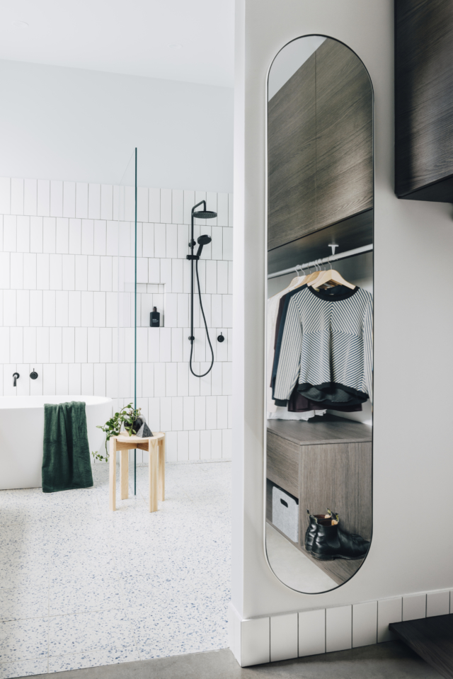 AFTER A custom oval mirror echoes the curves found in the nearby bathroom