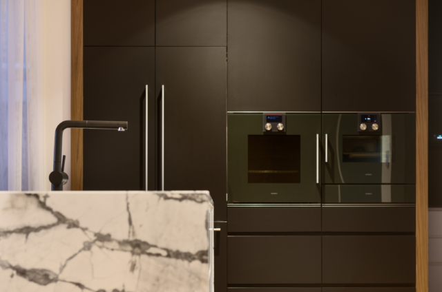 The concealed fridge sits next to Gaggenau appliances