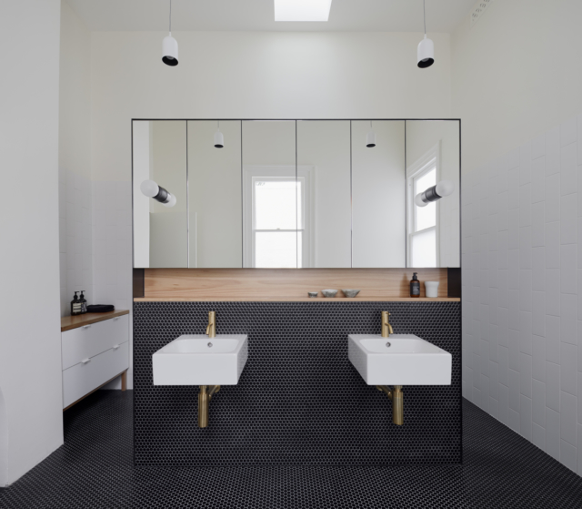 The ensuite is divided by a wall that conceals the toilet and shower behind