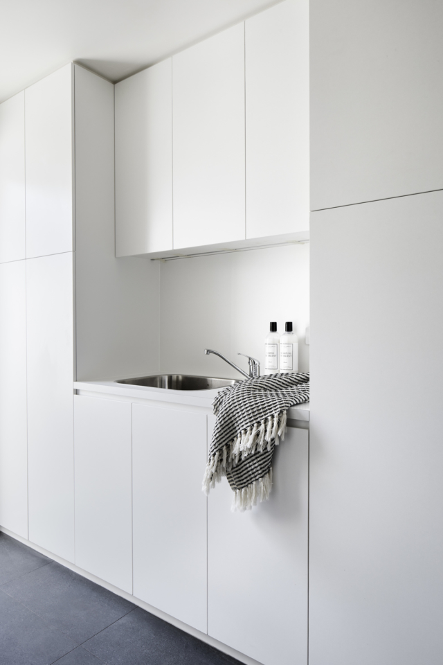 The laundry is concealed behind the blue kitchen