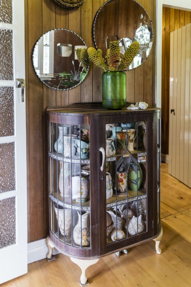 Old mirrors and a beautiful cupboard filled with old finds give the home so much character